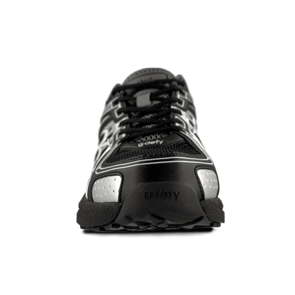 Athletic shoe in black and silver with mesh upper and synthetic overlays, featuring g-defy branding on the toe.