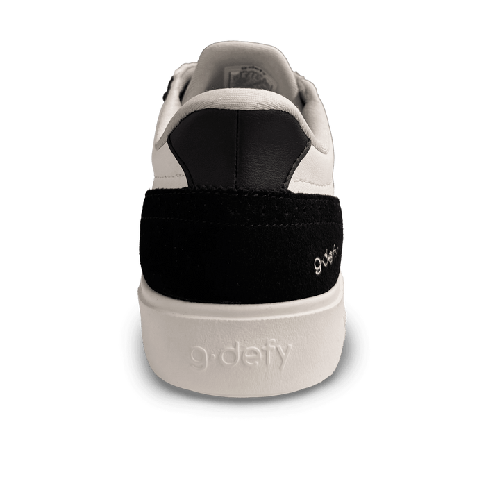White leather and black suede sneaker, back view, featuring "g-defy" embossed on the white sole and embroidered on the heel.