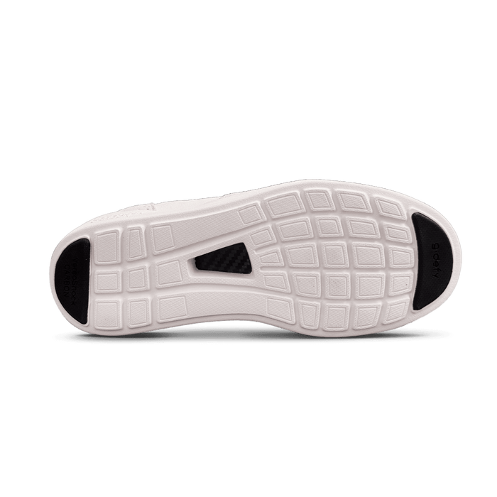 Bottom of a white shoe sole with a grid pattern, black VersaShock Carbon toe, g-defy heel, and carbon fiber mid-sole.