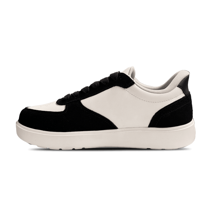 Black and white low-top sneaker with white leather upper and black suede accents, visible from the side.